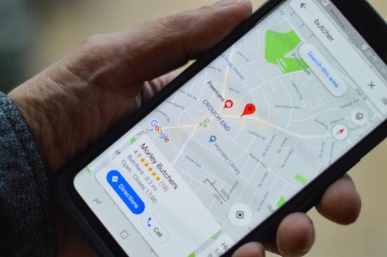 Smartphone met Google My Business pin – Zet je horecazaak op de kaart met marketingtips van Van Geloven